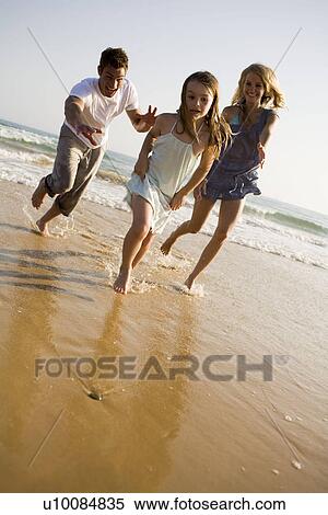 Stock Photography - Family on beach playing together. Fotosearch