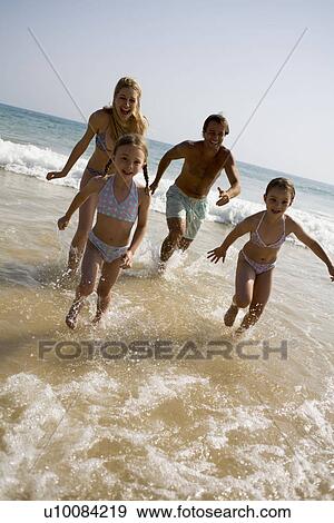 Family on beach running out of sea View Large Photo Image Stock Photo - Family on beach running out of sea. Fotosearch