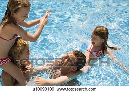 Stock Photo - Family playing in pool. Fotosearch