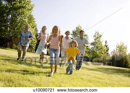 Stock Image - Grandparents and family in park. Fotosearch