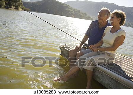 Mature couple by lake fishing View Large Photo Image Stock Image - Mature couple by lake fishing. Fotosearch