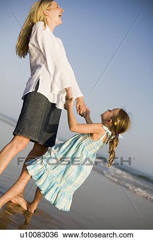 Stock Photograph - Mother and daughter on beach. Fotosearch