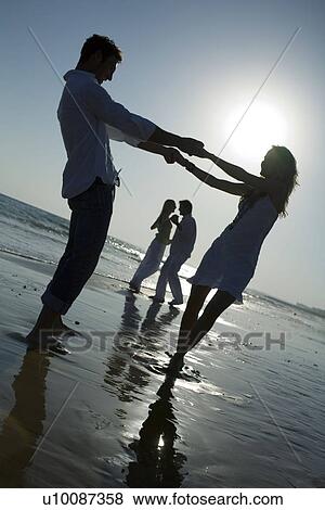 Two couples walking on beach View Large Photo Image Stock Photo - Two couples walking on beach . Fotosearch