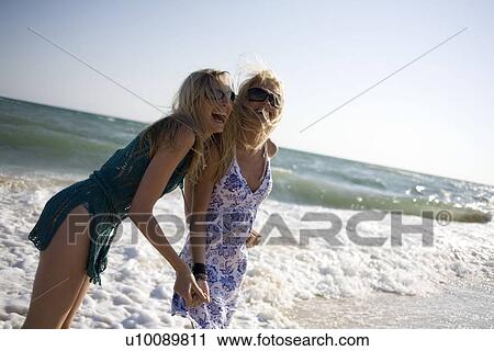 Stock Image - Two women on beach. Fotosearch