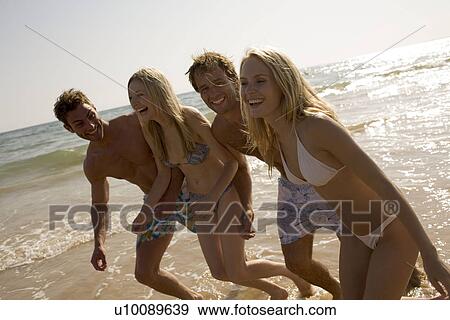 Stock Photo - Two young couples on beach. Fotosearch