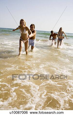 Stock Photograph - Two young couples on beach. Fotosearch