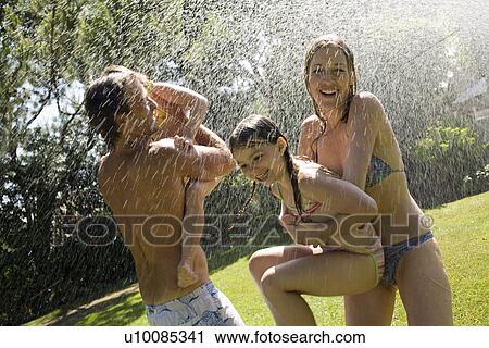 Stock Image - Family at home playing in garden. Fotosearch