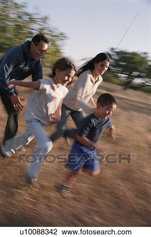 Family in park running in field View Large Photo Image Stock Image - Family in park running in field. Fotosearch