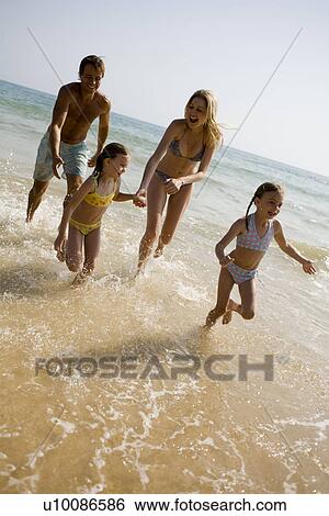 Family on beach running out of sea View Large Photo Image Stock Photograph - Family on beach running out of sea. Fotosearch
