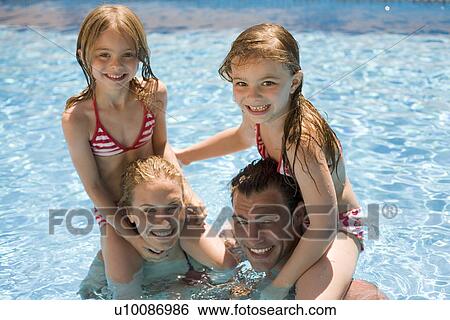 Stock Photograph - Family playing in pool. Fotosearch