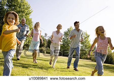 Stock Image - Grandparents and family in park. Fotosearch