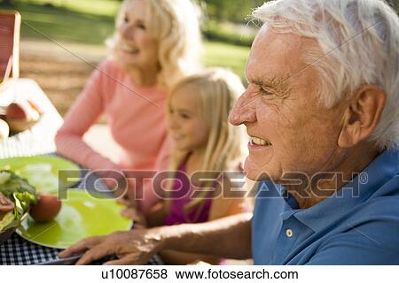 Stock Photo - Grandparents and family in park with picnic. Fotosearch