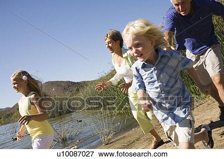 Stock Photo - Grandparents and grandchildren by lake. Fotosearch