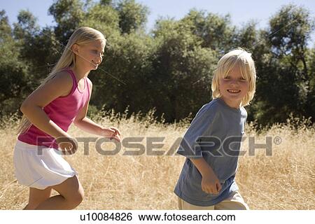 Young boy and young girl in park View Large Photo Image Stock Photograph - Young boy and young girl in park. Fotosearch