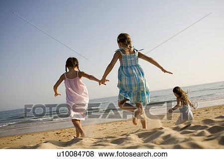 Stock Photo - Children playing on beach. Fotosearch
