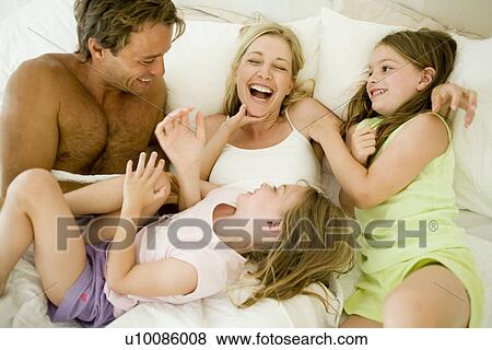 Stock Photo - Family at home in bedroom. Fotosearch