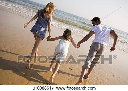 Stock Photo - Family on beach playing together. Fotosearch