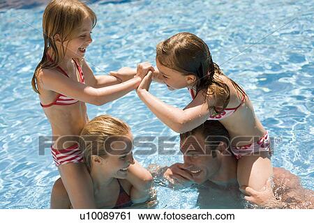 Stock Image - Family playing in pool. Fotosearch