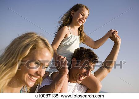 Stock Photography - Family playing on beach. Fotosearch