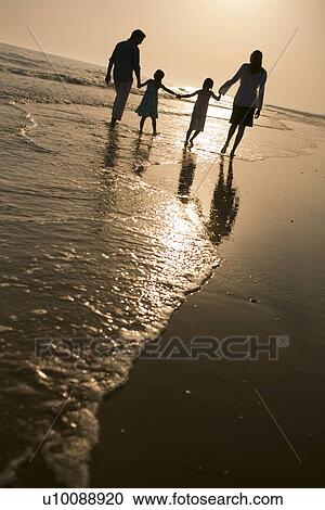 Stock Image - Family walking on beach. Fotosearch