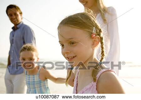 Stock Photo - Family walking on beach. Fotosearch