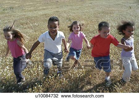 Stock Image - Five children running in field. Fotosearch