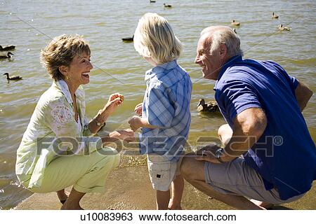Grandparents and grandchild by lake View Large Photo Image Stock Image - Grandparents and grandchild by lake. Fotosearch