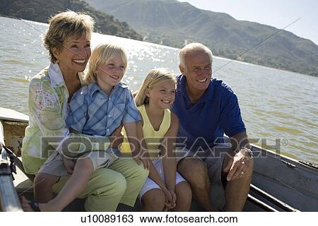 Stock Image - Grandparents and grandson in boat. Fotosearch