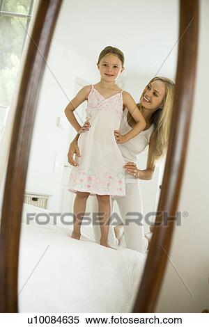 Stock Photography - Mother and daughter looking in mirror. Fotosearch