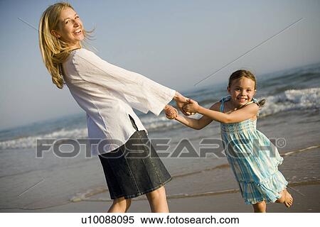 Stock Photography - Mother and daughter on beach. Fotosearch
