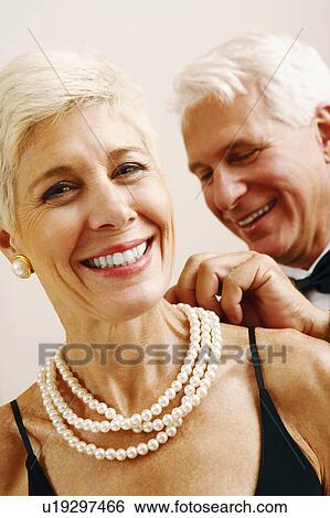 Close-up of a mature man putting a pearl necklace around a senior woman's neck View Large Photo Image Stock Photograph - Close-up of a mature man putting a pearl necklace around a senior woman's neck. Fotosearch