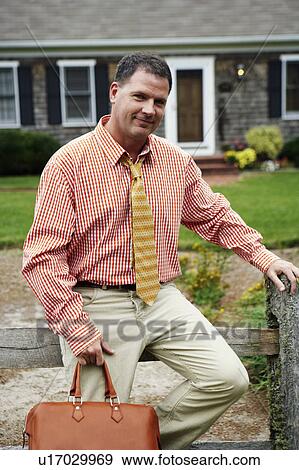 Portrait of a businessman holding a hand bag and smiling View Large Photo Image Stock Photo - Portrait of a businessman holding a hand bag and smiling. Fotosearch
