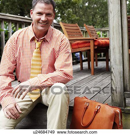 Portrait of a businessman sitting and smiling View Large Photo Image Stock Photo - Portrait of a businessman sitting and smiling. Fotosearch