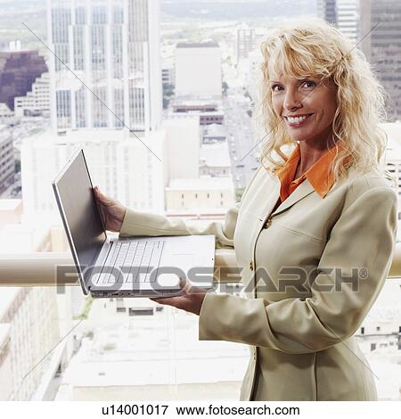 Stock Photo - Portrait of a businesswoman holding a laptop. Fotosearch