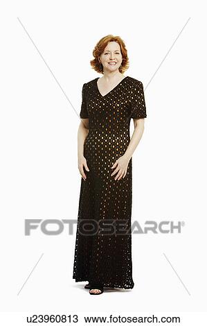 Portrait of a mature woman standing and smiling View Large Photo Image Stock Image - Portrait of a mature woman standing and smiling. Fotosearch