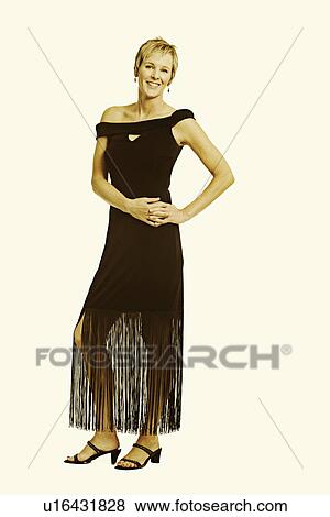 Portrait of a mature woman standing with her hand on her hip View Large Photo Image Stock Photo - Portrait of a mature woman standing with her hand on her hip. Fotosearch
