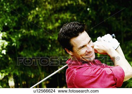 Picture - Close-up of a mature man playing golf and smiling. Fotosearch