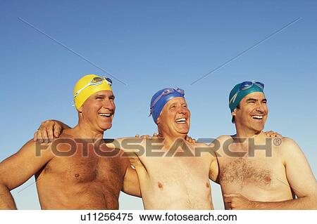 Stock Photography - Close-up of three mature men standing side by side and smiling. Fotosearch