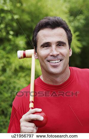 Portrait of a mature man holding a croquet mallet and a ball View Large Photo Image Stock Photo - Portrait of a mature man holding a croquet mallet and a ball. Fotosearch