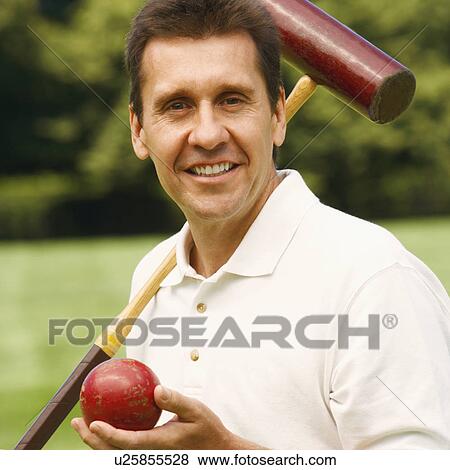 Portrait of a mature man holding a croquet mallet and a ball View Large Photo Image Stock Photo - Portrait of a mature man holding a croquet mallet and a ball. Fotosearch