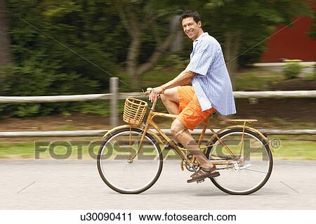 Stock Image - Side profile of a mature man cycling. Fotosearch