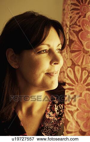 Stock Photo - Close-up of a mature woman looking away and smiling. Fotosearch