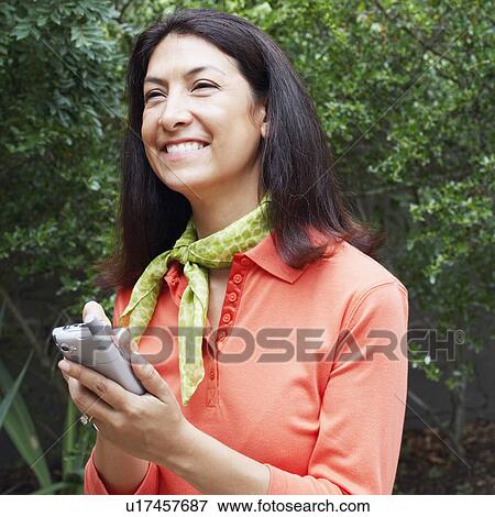 Stock Photo - Close-up of a mature woman operating a personal data assistant. Fotosearch