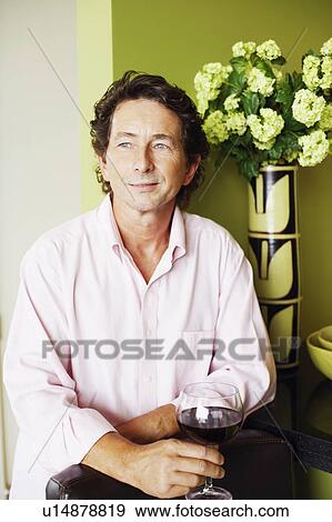 Stock Photo - Mature man holding a glass of wine. Fotosearch