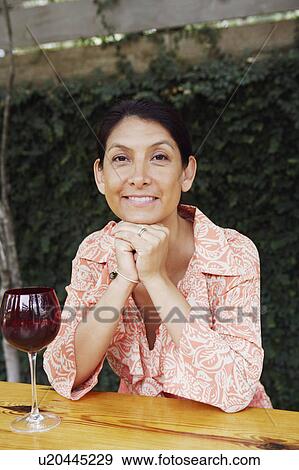 Portrait of a mature woman sitting at the table and smiling View Large Photo Image Stock Photo - Portrait of a mature woman sitting at the table and smiling. Fotosearch