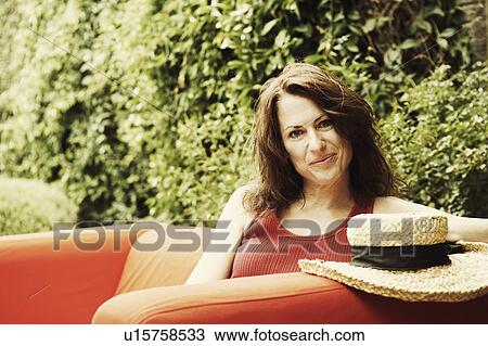 Portrait of a mature woman sitting in an armchair View Large Photo Image Stock Image - Portrait of a mature woman sitting in an armchair. Fotosearch