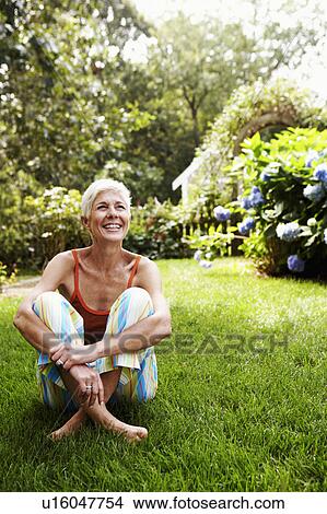 Close-up of a senior woman sitting on grass View Large Photo Image Picture - Close-up of a senior woman sitting on grass. Fotosearch