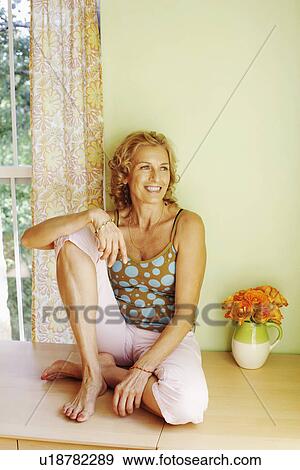 Stock Photo - Mature woman sitting and smiling. Fotosearch