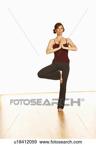 Mid adult woman standing in a tree pose View Large Photo Image Stock Photo - Mid adult woman standing in a tree pose. Fotosearch