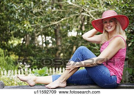 Portrait of a mature woman sitting on a railing View Large Photo Image Stock Photo - Portrait of a mature woman sitting on a railing. Fotosearch